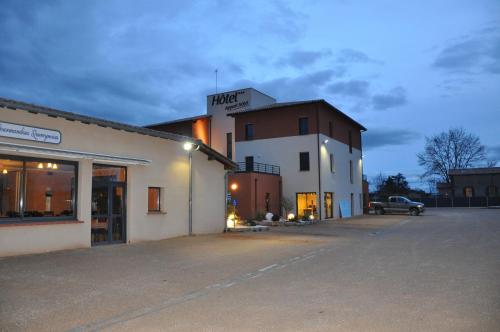 un aparcamiento vacío frente a un edificio en The Originals City, Hôtel des Arts, Montauban (Inter-Hotel), en Nègrepelisse