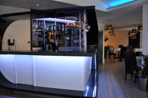 a bar in a restaurant with lights on it at The Originals City, Hôtel des Arts, Montauban in Nègrepelisse