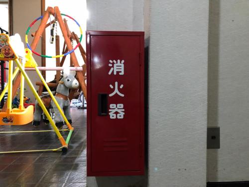 a red door with asian writing on it in a gym at kinugawaonsen Fukumatsu in Nikko