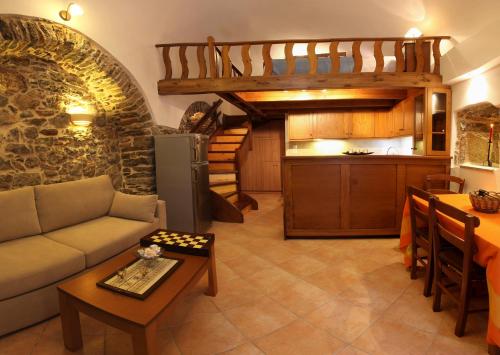 梅斯塔的住宿－STOES Traditional Suites，带沙发和桌子的客厅以及厨房。