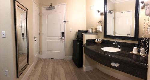 a bathroom with a sink, mirror, and bathtub at Gateway Inn and Suites San Francisco SFO Airport in San Bruno