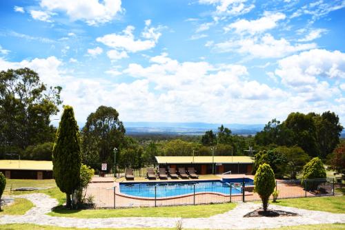 einen Pool in einem Park mit Stühlen und Bäumen in der Unterkunft Cherrabah Resort Warwick in Elbow Valley