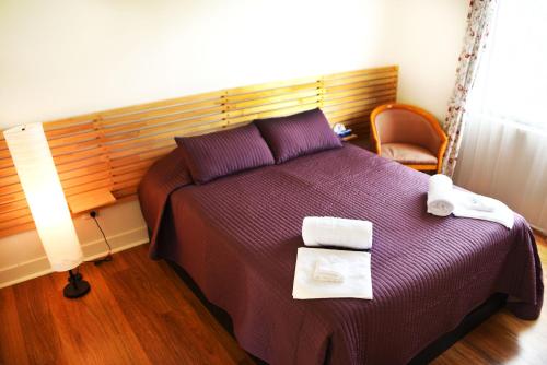 a bedroom with a purple bed with towels on it at Cherrabah Resort Warwick in Elbow Valley