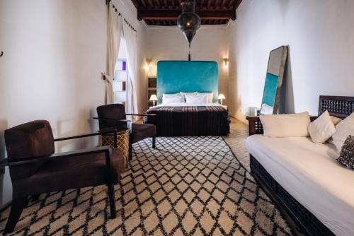 a hotel room with a bed and a couch at Riad Tizwa Marrakech in Marrakesh