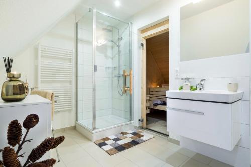 ein Bad mit einer Dusche und einem Waschbecken in der Unterkunft Ferienhaus Stella in Glowe