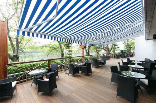 a restaurant with tables and chairs on a deck at Day Nice Hotel Tokyo in Tokyo