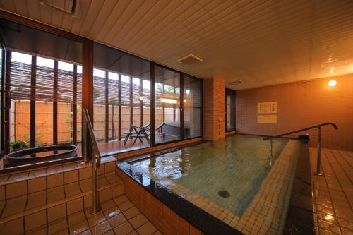 a hot tub in a room with a large window at Green Hotel Yes Ohmi-hachiman in Omihachiman