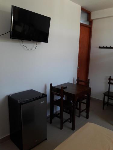 a living room with a table and a flat screen tv at Bungalows Rupay Wasi in Los Órganos