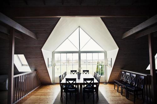 a dining room with a table and chairs and a large window at Abbekås Golfrestaurang & Hotell in Abbekås
