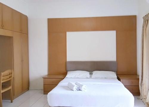 a bedroom with a bed with two white towels on it at Lumut Valley Condominium in Lumut