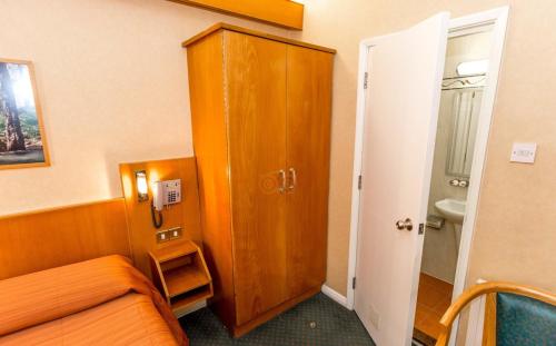a room with a couch and a cabinet and a bathroom at The Beverley House Hotel in London