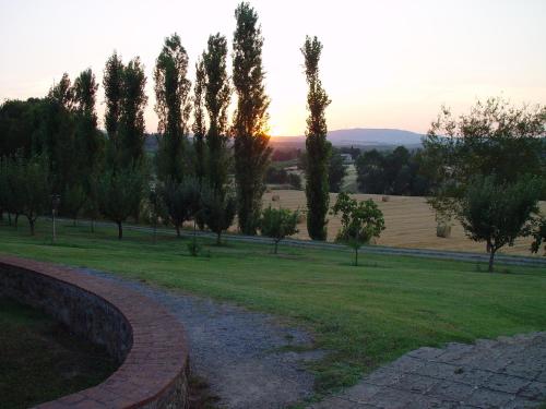 a path in a park with trees and a sunset at Agriturismo La Sovana in Sarteano