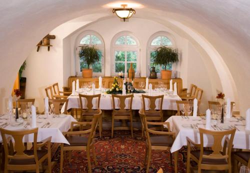 a large dining room with white tables and chairs at Waldhotel Nachtigall in Paderborn