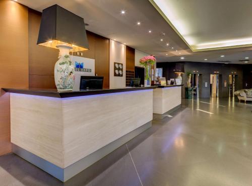 a lobby with a counter with a vase on it at Best Western Plus Hotel Expo in Villafranca di Verona