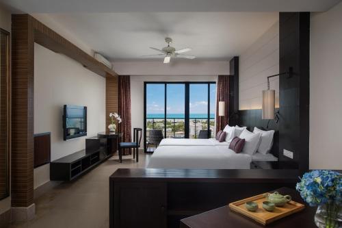 a hotel room with a bed and a television at Ramada Plaza by Wyndham Sanya Bay in Sanya
