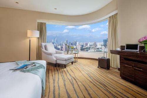 una camera d'albergo con vista sulla città di The Kunlun Jing An a Shanghai