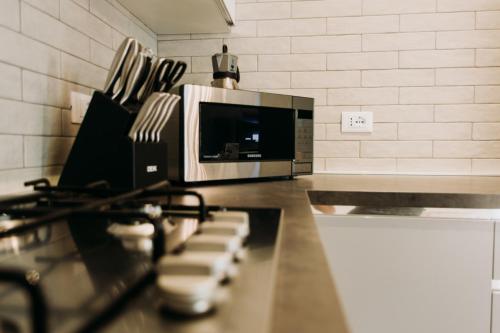 a kitchen counter with a stove and a microwave at Luxury Penthouse with Sea View - City Center in Pescara