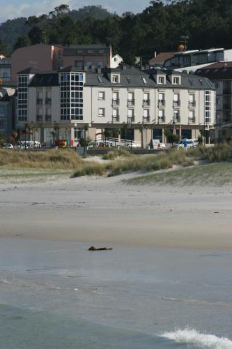a dog laying in the water on the beach at Hotel Playa de Laxe in Laxe