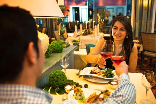 a man and woman sitting at a table with wine glasses at Strauers Hotel am See in Bosau