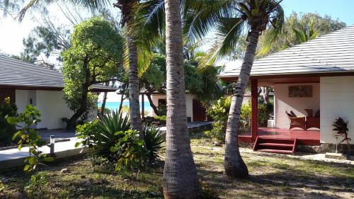 a house with palm trees in front of it at Hotel Paradis d'Ouvéa in Fayaoué