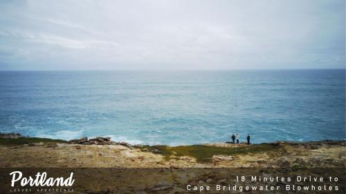 two people standing on a cliff near the ocean at Province in Portland