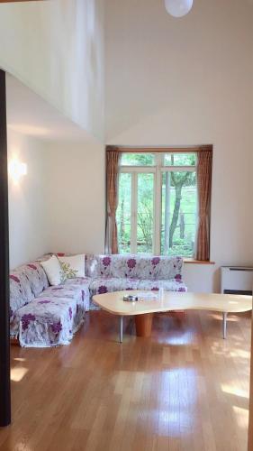 a living room with a couch and a table at Cottage Ginkai Fuji in Yamanakako