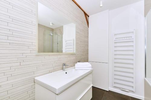 a white bathroom with a sink and a mirror at Chodkiewicza 10 (B) - cozy studio by Homeprime in Krakow