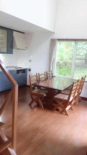 a dining room with a wooden table and chairs at Cottage Ginkai Fuji in Yamanakako