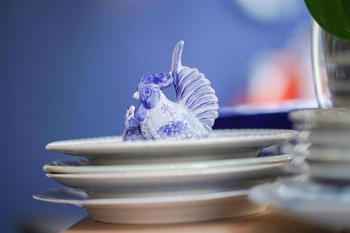 a stack of white plates with a bird on them at Amistad hotel in Amsterdam