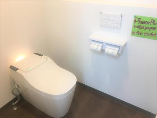 a white toilet in a bathroom with two rolls of toilet paper at Kagoshima Little Asia in Kagoshima