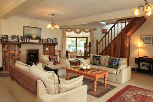 a living room with white furniture and a fireplace at Mont Fleur B&B in Wilderness