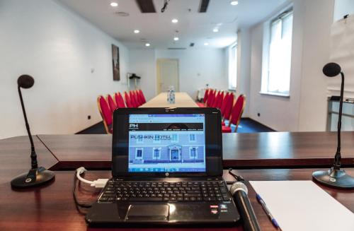 a laptop computer sitting on a table in a conference room at Hotel Pushkin in Uralsk