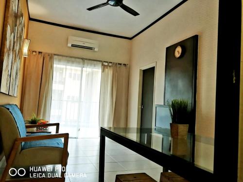 ein Wohnzimmer mit einem Glastisch und einem Fenster in der Unterkunft M.R Homestay Morib Gold Coast Resort in Banting