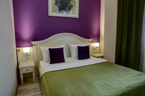 a bedroom with a large bed and a large window at Hotel Gorenje in Prishtinë