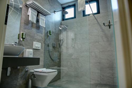 a bathroom with a shower and a toilet and a sink at Hotel Gorenje in Prishtinë
