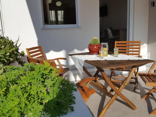 drewniany stół i krzesła w pokoju z roślinami w obiekcie Minimalistic Apartment Near the Sea w mieście Guwes