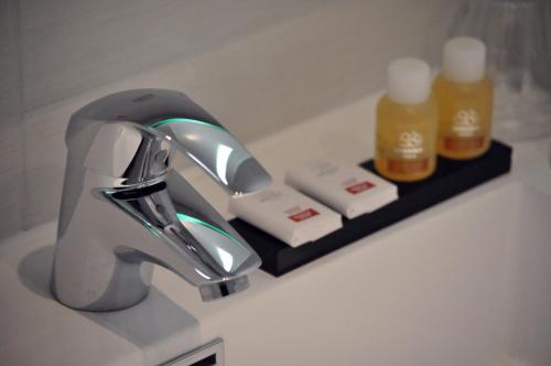 a bathroom sink with a faucet and two bottles of soap at The Concert Hotel in Amsterdam
