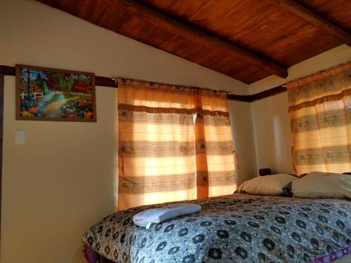 a bedroom with a bed in front of a window at Termas El Pantanal in Papallacta