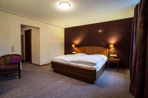 a bedroom with a large bed with a wooden headboard at Hotel Karpfen in Eberbach