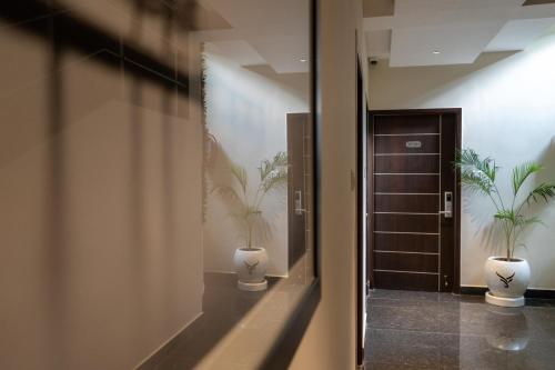 a hallway with two potted plants and a door at The Bull Boutique Hotel in Pondicherry