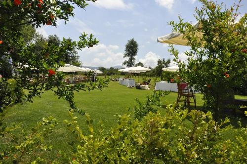 a lawn with tables and umbrellas in a garden at Borgo Patierno in Conca della Campania