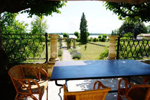 une table bleue et des chaises sur une terrasse avec un jardin dans l'établissement Villa Bacchus, à Bourg