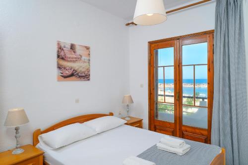 a bedroom with a bed with a view of the ocean at Sunset House Skala Maries in Skala Marion