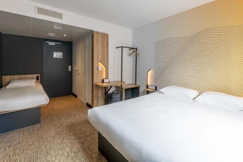 a hotel room with a large bed and a desk at B&B HOTEL Bordeaux Centre Gare Saint-Jean in Bordeaux
