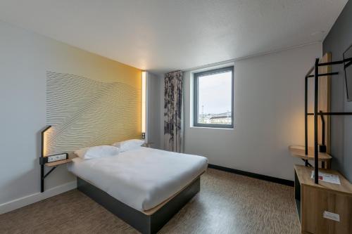 a hotel room with a bed and a window at B&B HOTEL Bordeaux Centre Gare Saint-Jean in Bordeaux