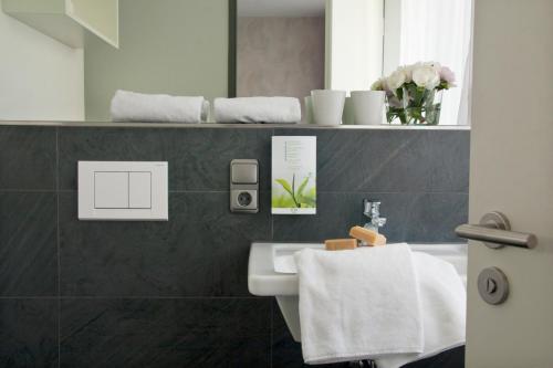 ein Bad mit einem Waschbecken und einem weißen Handtuch in der Unterkunft Boardinghouse Landshut in Landshut