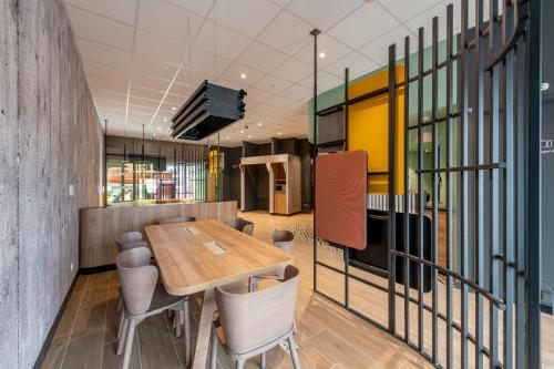 a dining room with a wooden table and chairs at B&B HOTEL Bordeaux Centre Gare Saint-Jean in Bordeaux