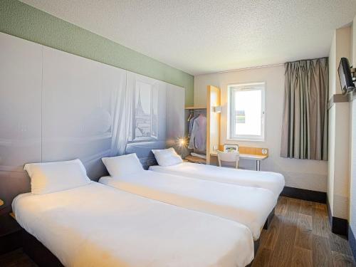 Ένα ή περισσότερα κρεβάτια σε δωμάτιο στο B&B HOTEL Orleans Saint-Jean de Braye