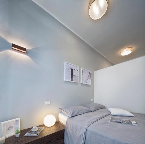 a bedroom with a bed and a table with two lamps at Suite Vogue City in Voghera