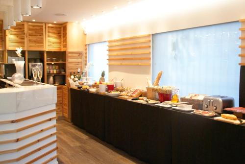 a buffet line with food on display in a restaurant at Hotel Sitges in Sitges